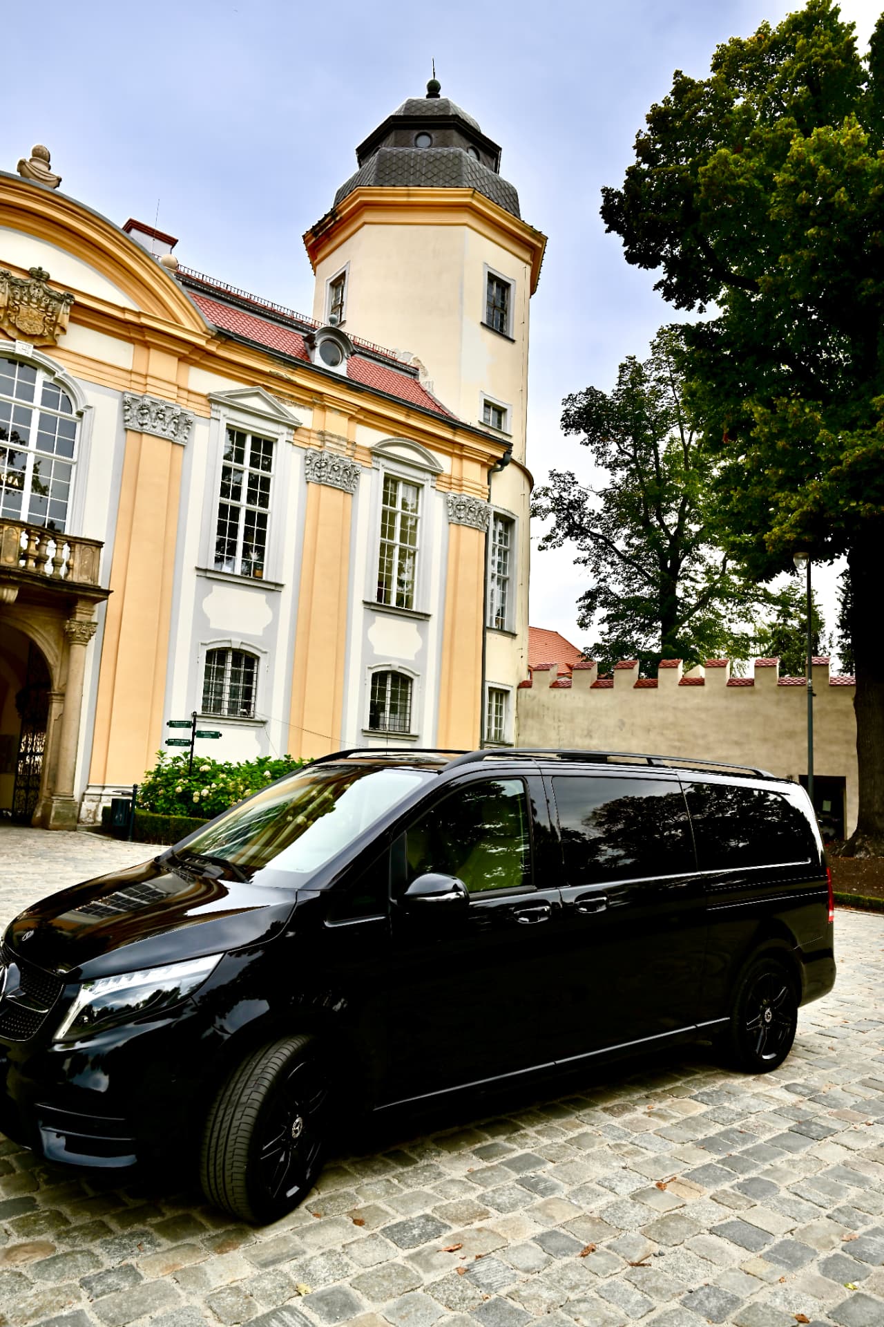 Czarny Mercedes V klasa z czarnymi felgami na dziedzińcu pałacu